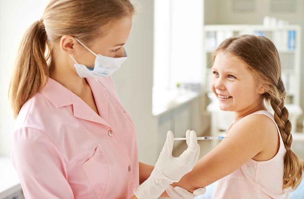 Nurse injecting a smiling girl