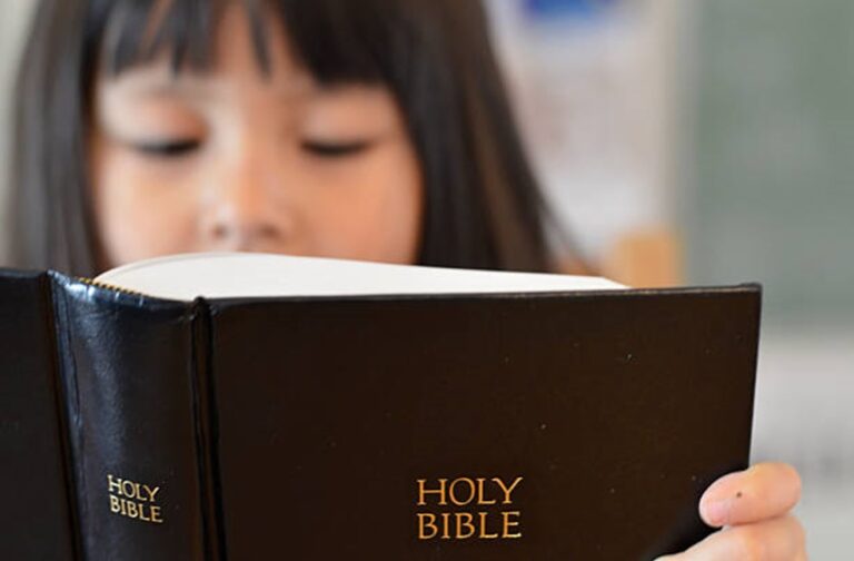 Little asian reading her Bible