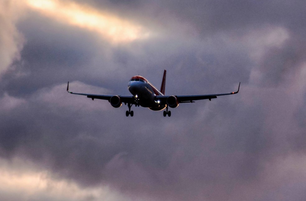 Low angle shot of an airplane descending from a clouded sky