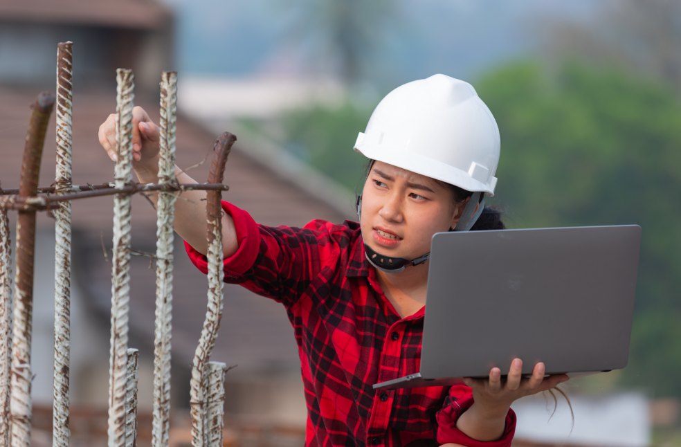 Engineer holding laptop check the construction work