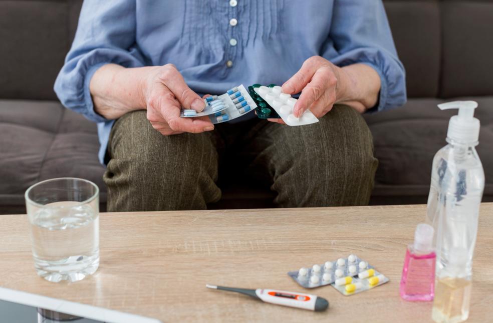 Front view of elder woman taking her pills