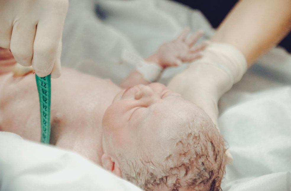 Health Personnel Measuring a Newborn Baby