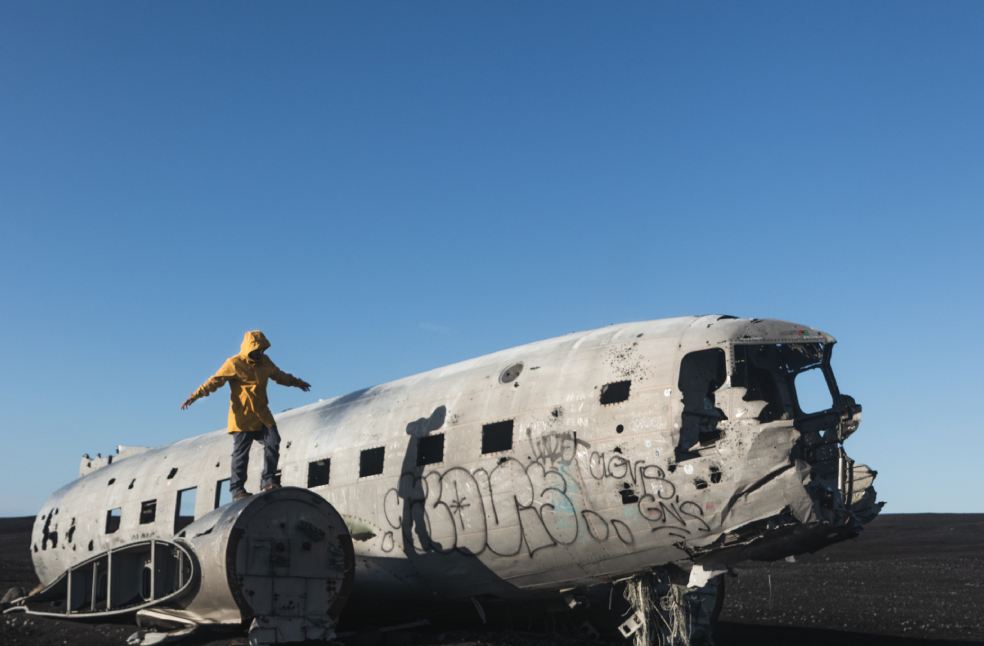 Man standing on an abandoned crashed plane