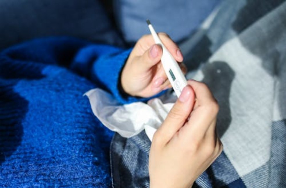 Thermometer reading taken by person with flu
