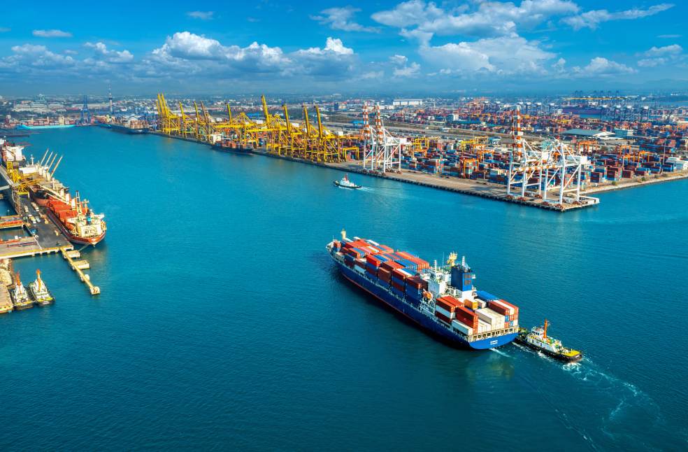 Aerial view of cargo ship and cargo container in harbor.