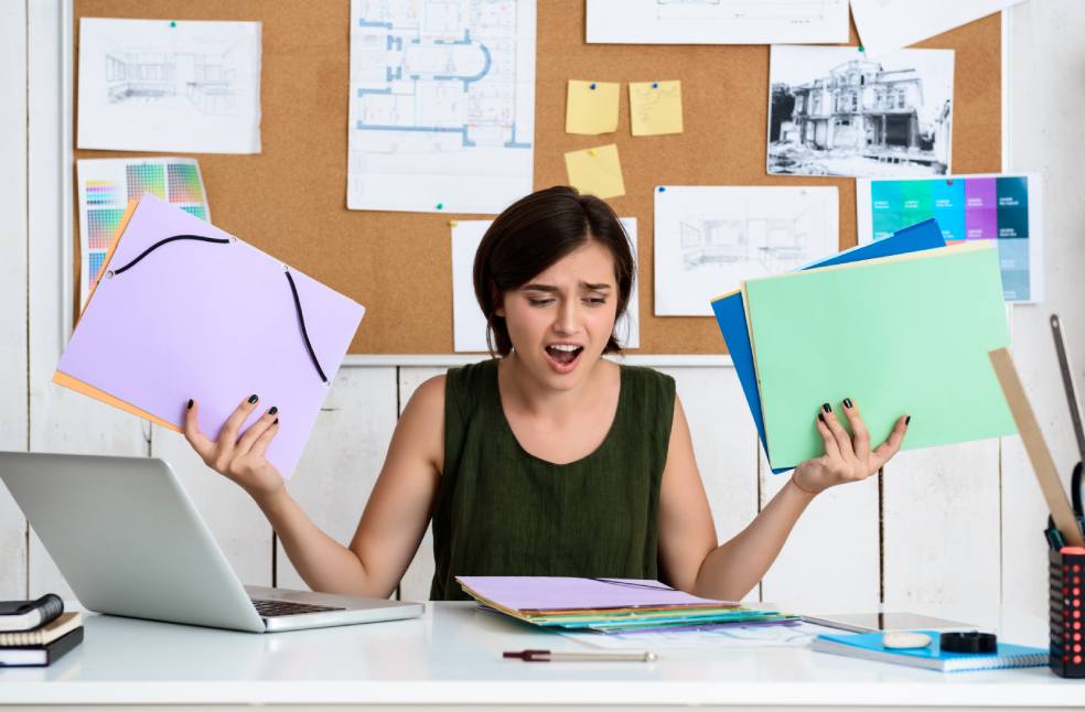 Upset young beautiful businesswoman sitting at workplace