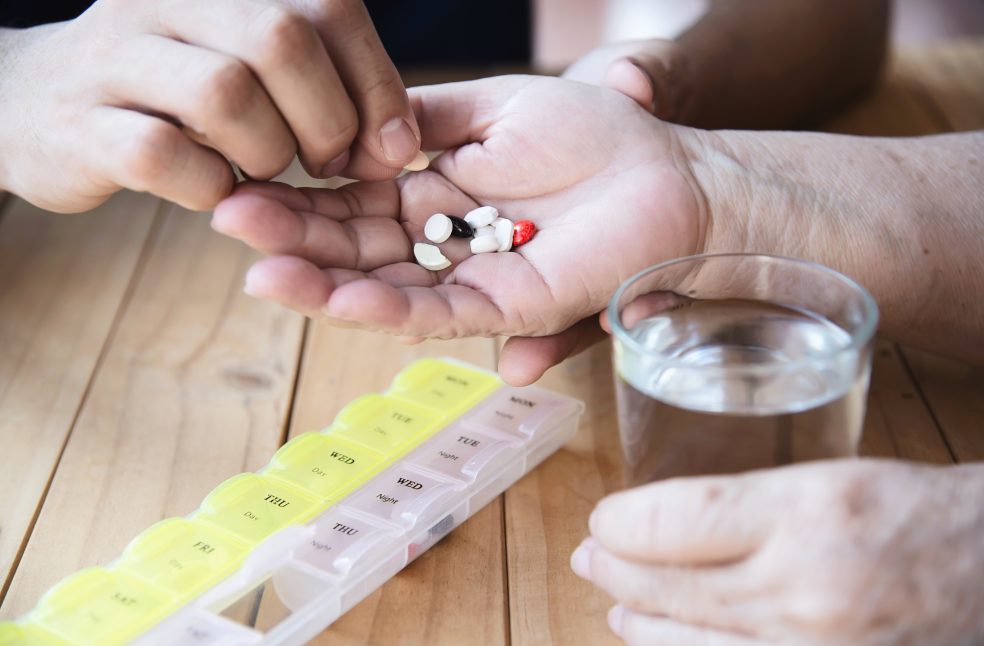 Doctor is assist patient to eat medicine tablet in pillbox correctly