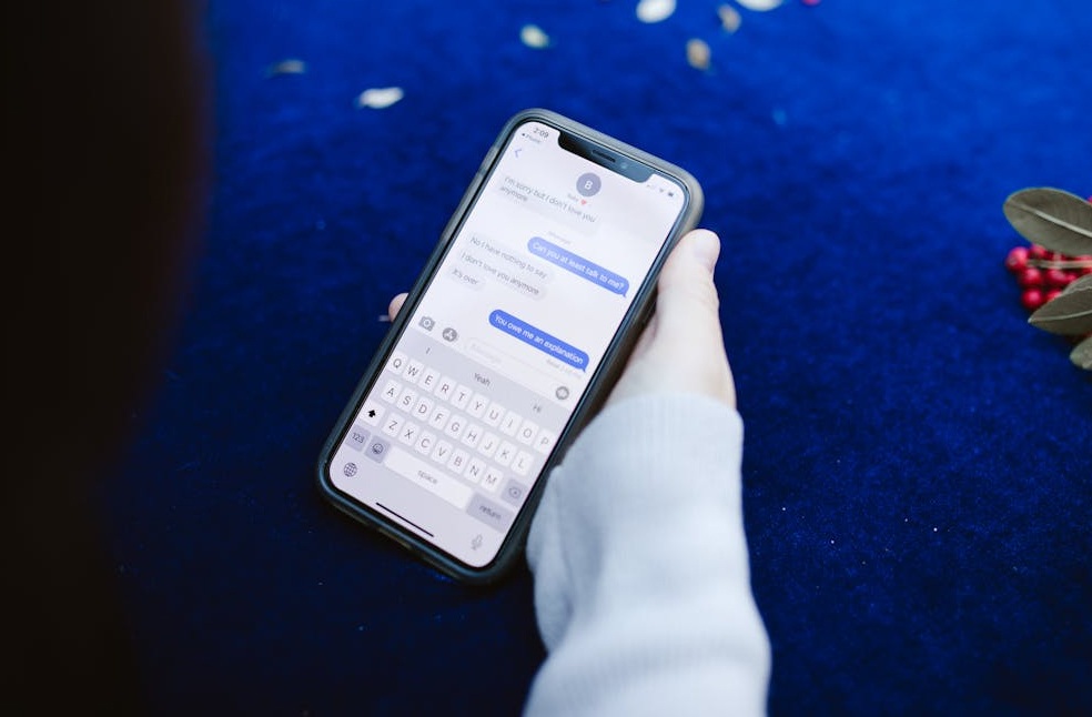 Person's Hand Showing Text Messages on Cellphone