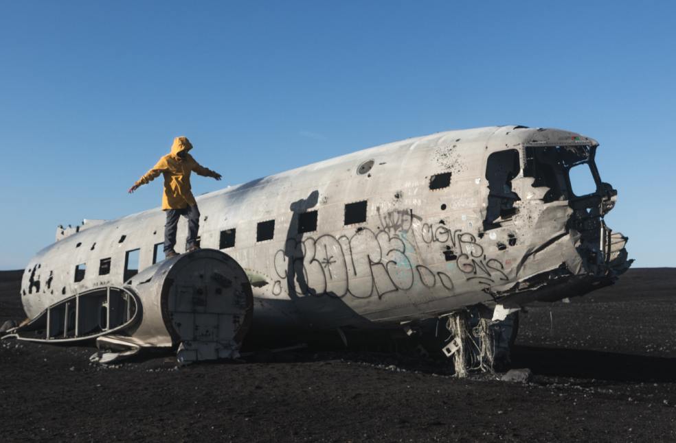 Man standing on an abandoned crashed plane 