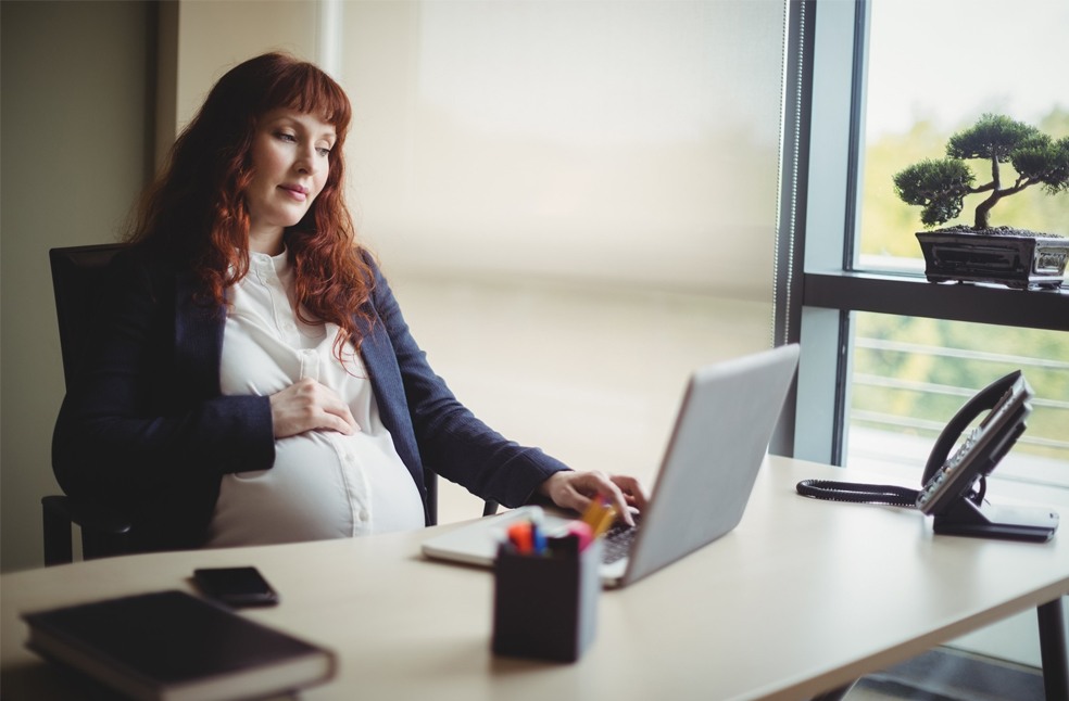 A pregnant woman working in the office
