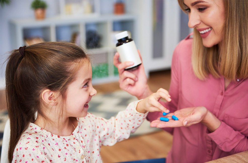 A mother giving medicine to her daughter
