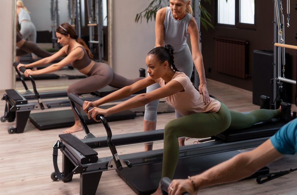 A lady instructor in a reformer pilates class