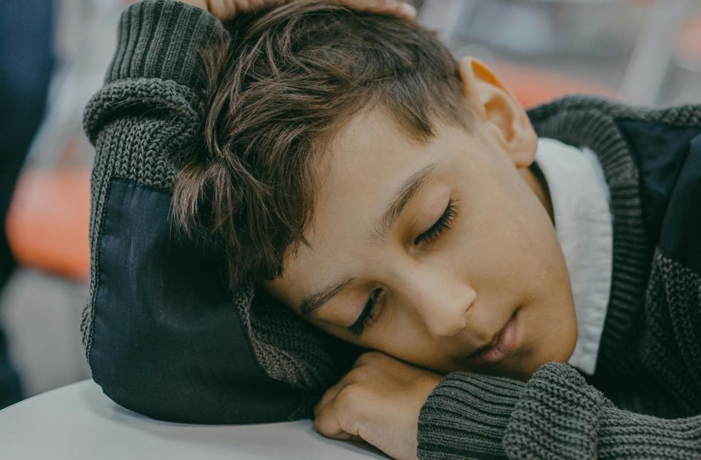 A child peacefully sleeping on a desk in a classroom
