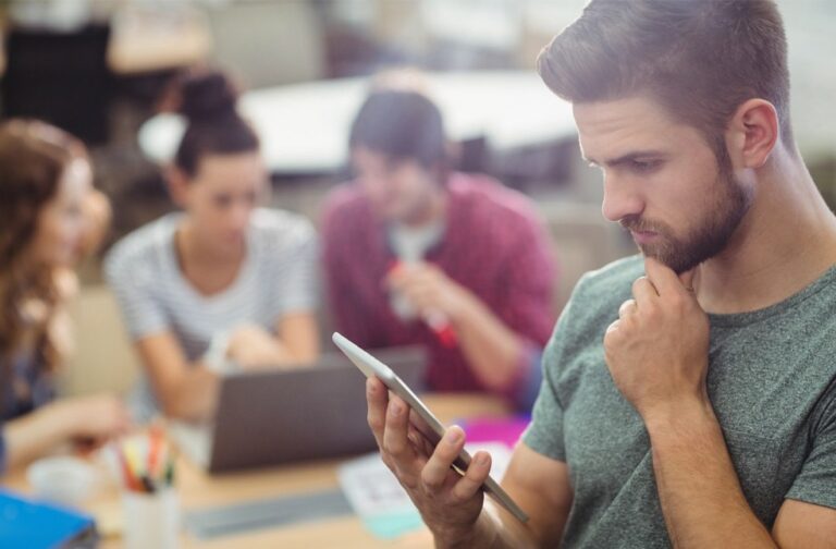 Growing dependence on AI systems sparks expert concern Man thinking deeply, holding a phone