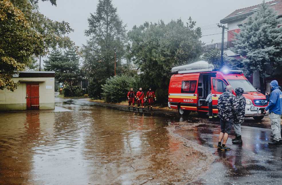 Emergency personnel managing flood with rescue vehicle