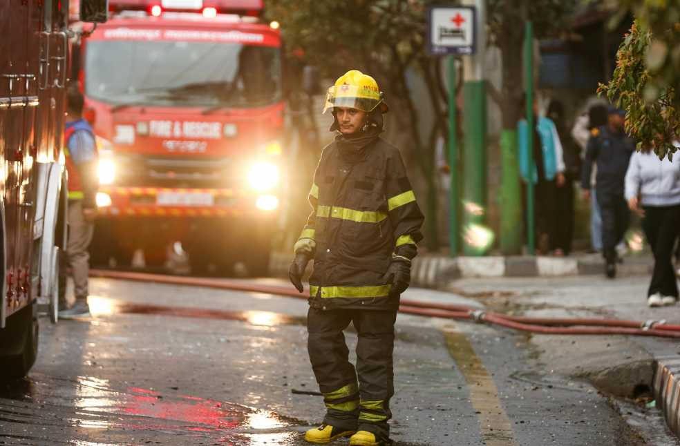 Firefighter in uniform stands near a fire truck