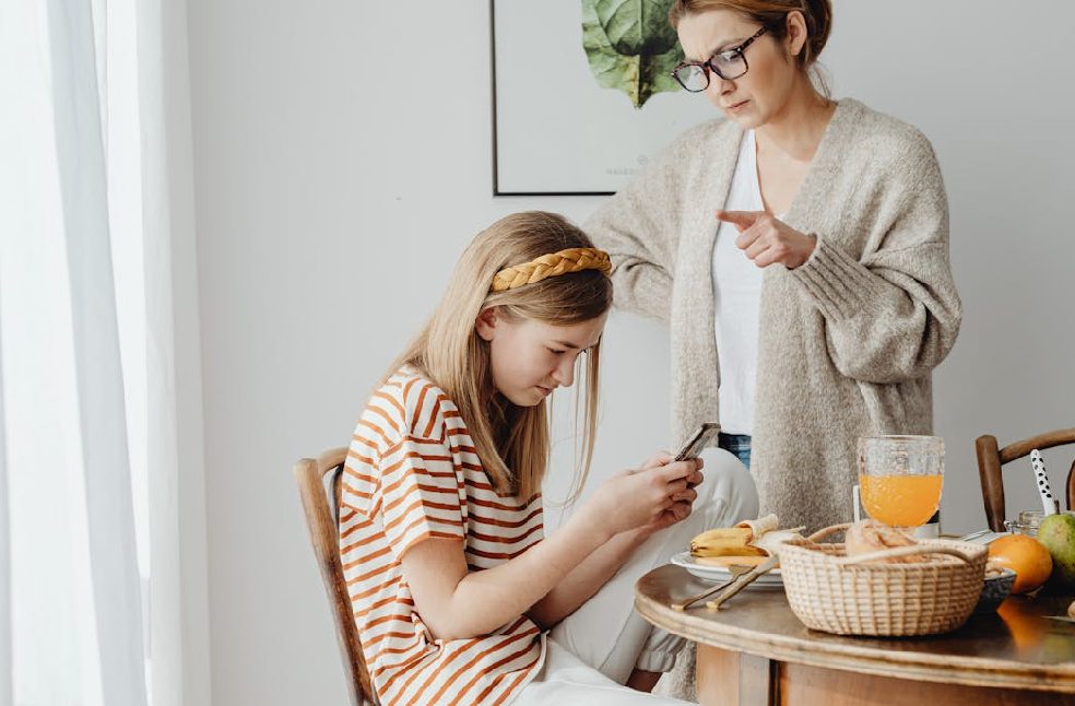 A mother scolds her teenage daughter for using a cellphone