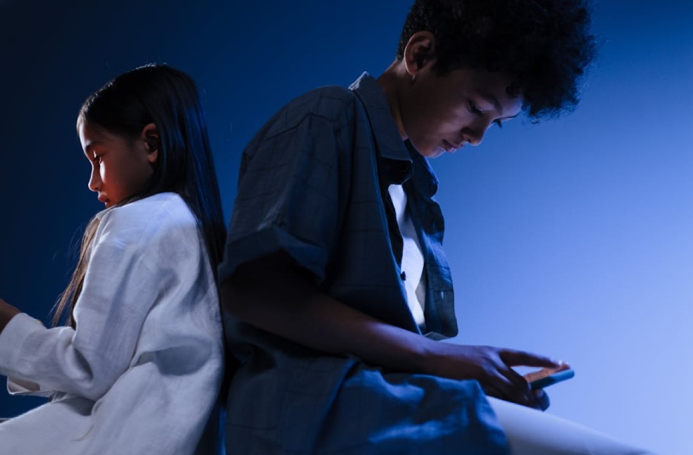 Young boy and girl using mobile devices