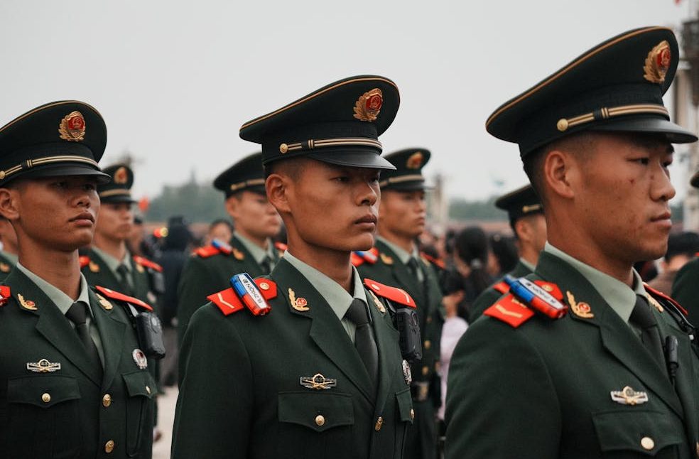 Close-up of military personnel in green uniforms and hats during a parade.