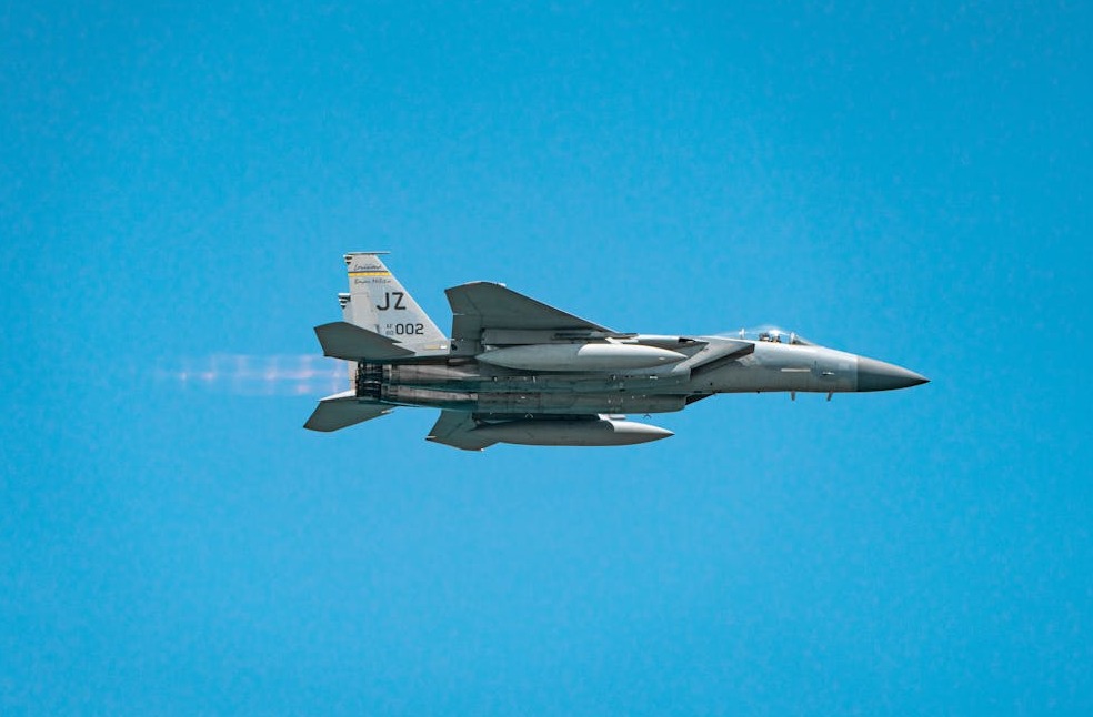 A military jet soaring through a clear blue sky