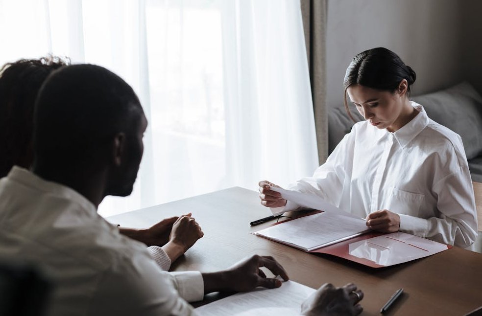A professional woman reviews documents with a couple