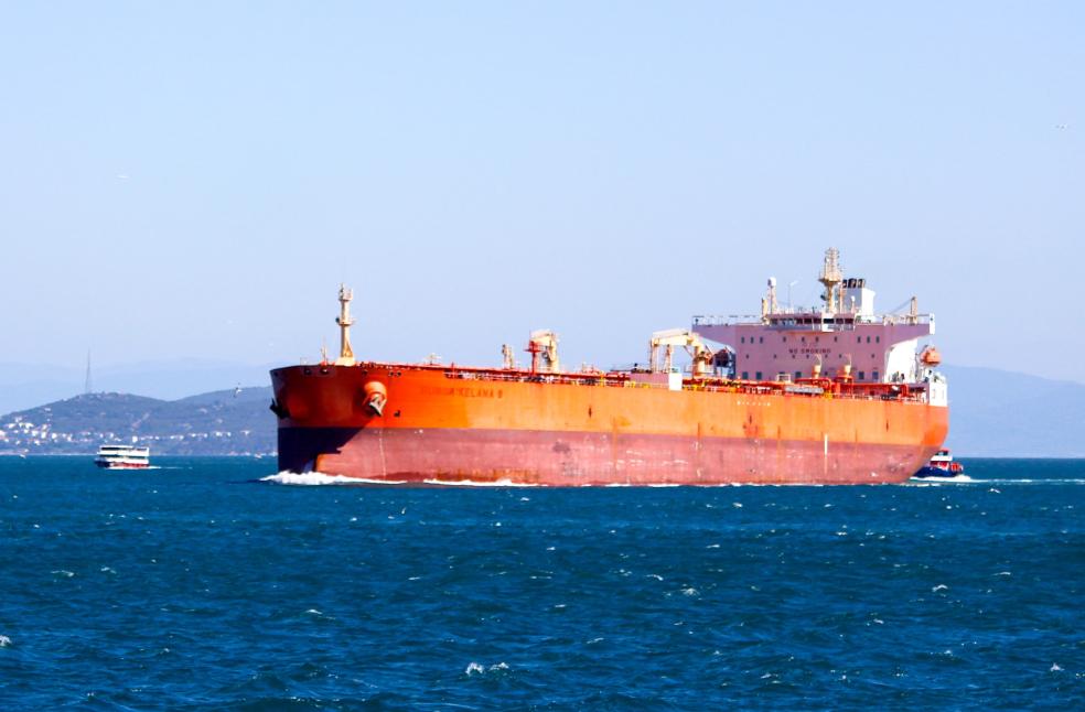 A large cargo ship navigating the open blue sea under a clear sky