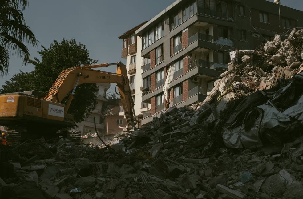 Excavator removing rubble from a collapsed building area