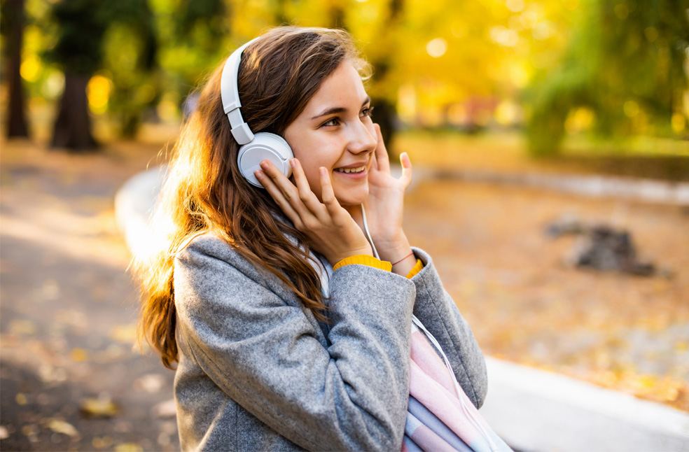A happy woman listening to music outdoors