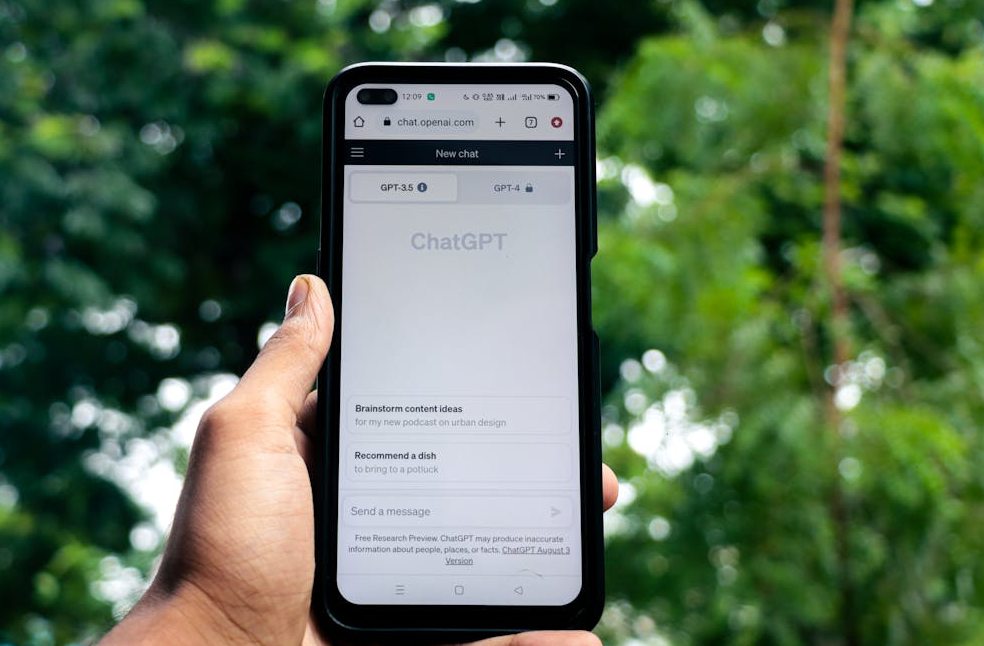 Close-up of a hand holding a smartphone displaying ChatGPT outdoors