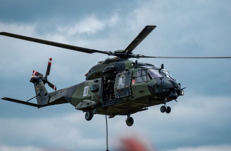 US launches strikes on Iran following helicopter attack Military helicopter flying through cloudy skies during a training exercise