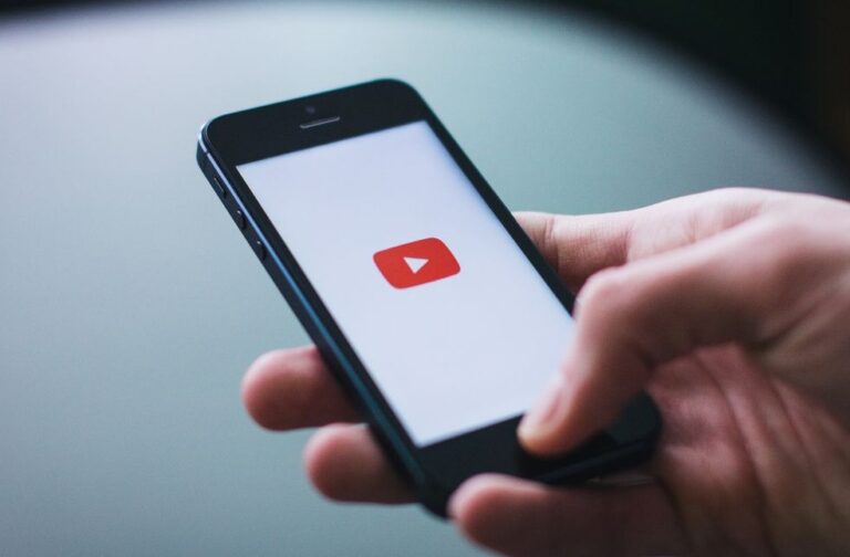 Google reaches settlement in YouTube addiction case Close-up of a hand holding a smartphone displaying the YouTube app on the screen