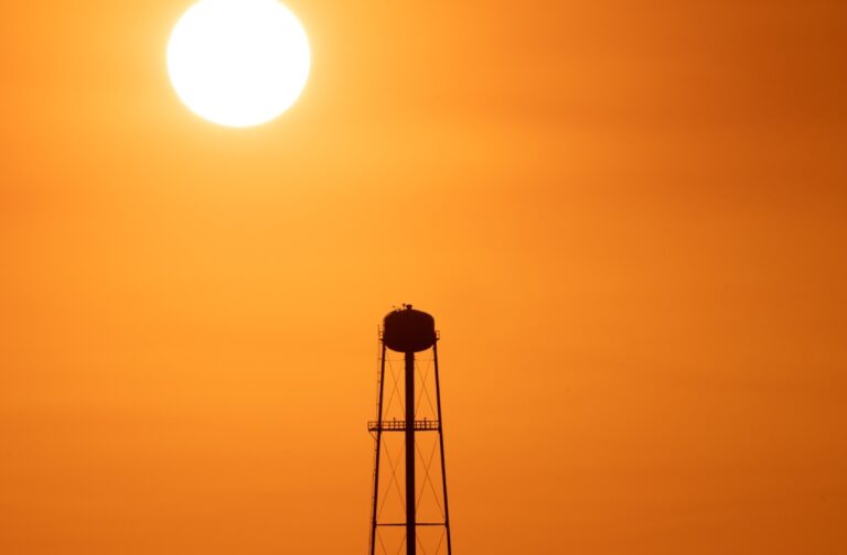 More than 2,700 heat-related deaths linked to UK heatwaves A striking sunset silhouette of a water tower against a vivid orange sky
