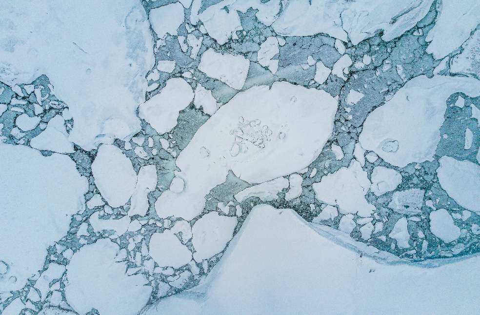 Stunning aerial shot of icy arctic landscape showcasing floating ice and calm winter sea