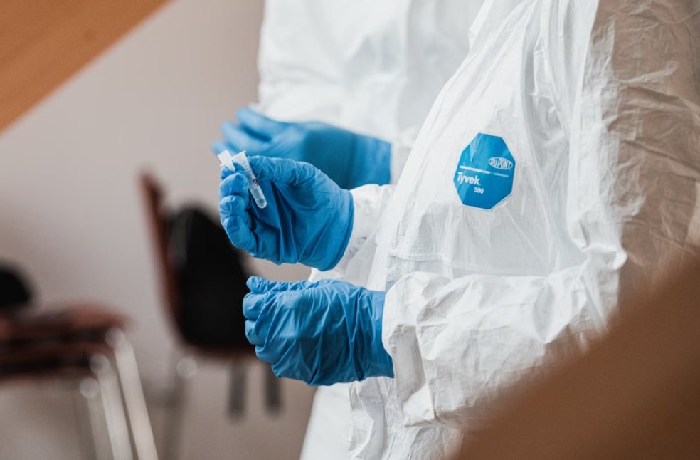 Professionals in protective gear handling test samples safely in a lab setting