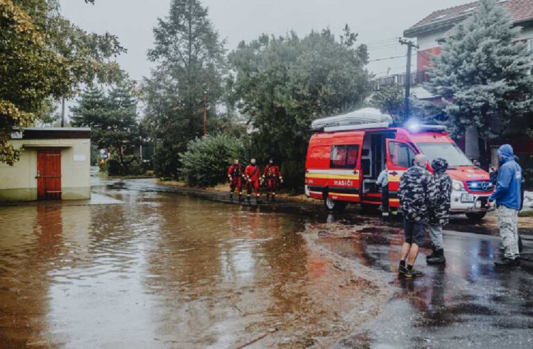 Heavy storms trigger flood emergency across Texas Emergency personnel managing flood with rescue vehicle. Urban scene with standing water.