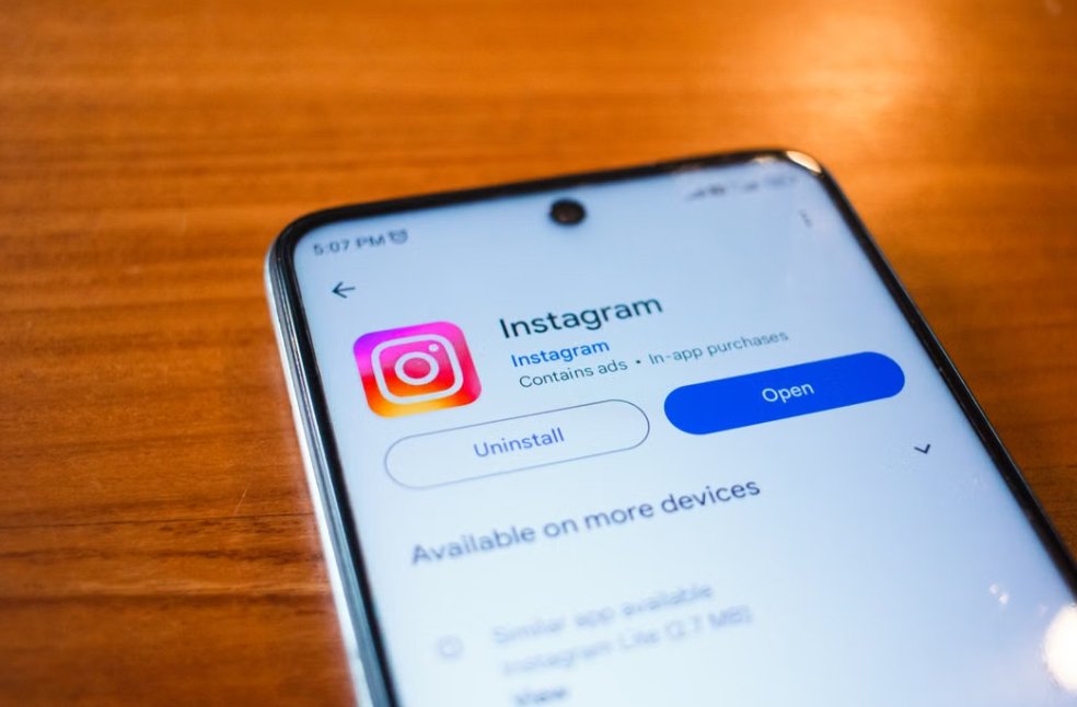 A smartphone displaying the Instagram app open option on a wooden table