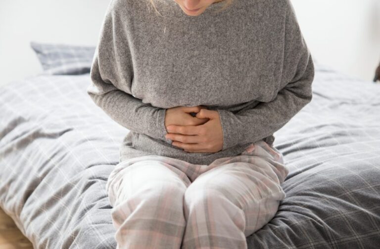 Sexually transmitted shigella cases surge across UK hands on stomach suffering from intense pain