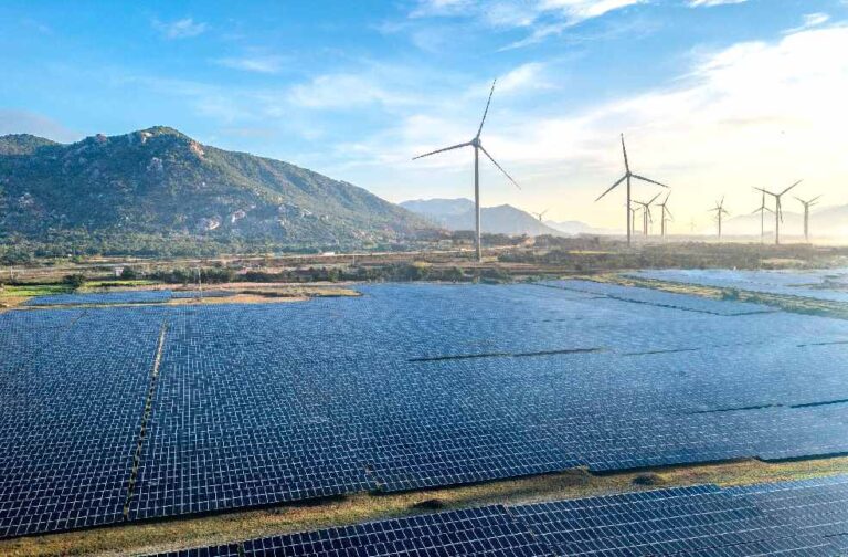 India solar expansion slows with factory supply constraints Aerial view of a solar and wind energy farm set against Vietnam's scenic landscape.