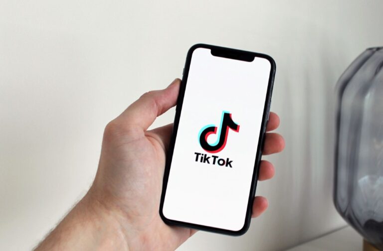 US lifts TikTok ban on federal government devices Close-up of a hand holding a smartphone displaying the TikTok app logo