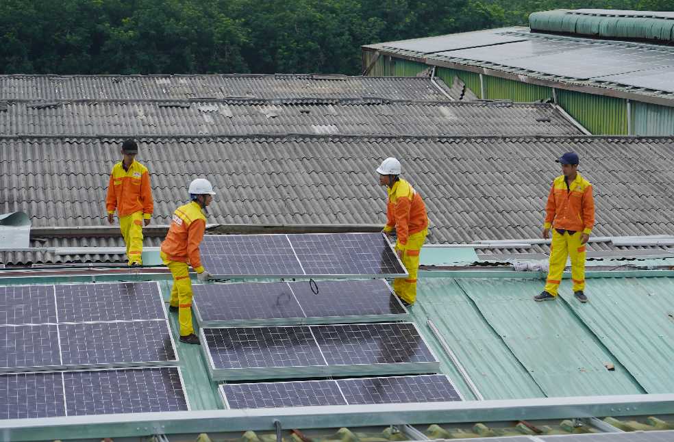 Workers installing solar panels on a roof for sustainable energy solutions