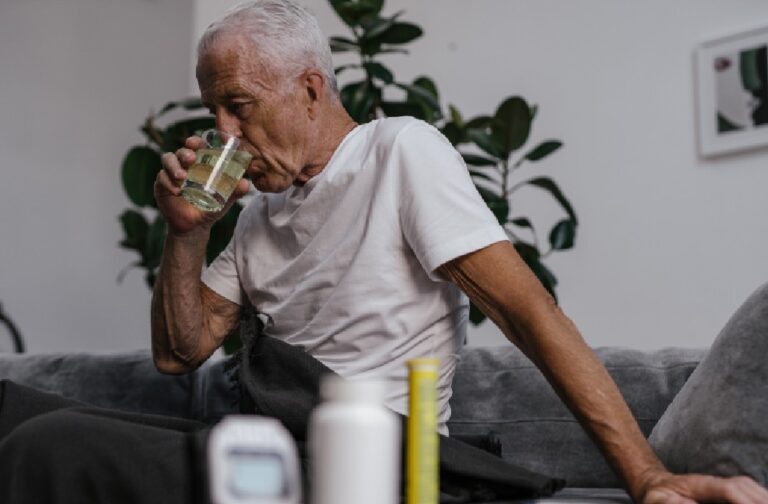 France heatwaves expose growing threat to ageing population Senior man in white shirt drinking medicine indoors. Health and wellness lifestyle