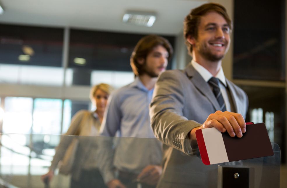 Businessman standing with boarding pass at check-in counter