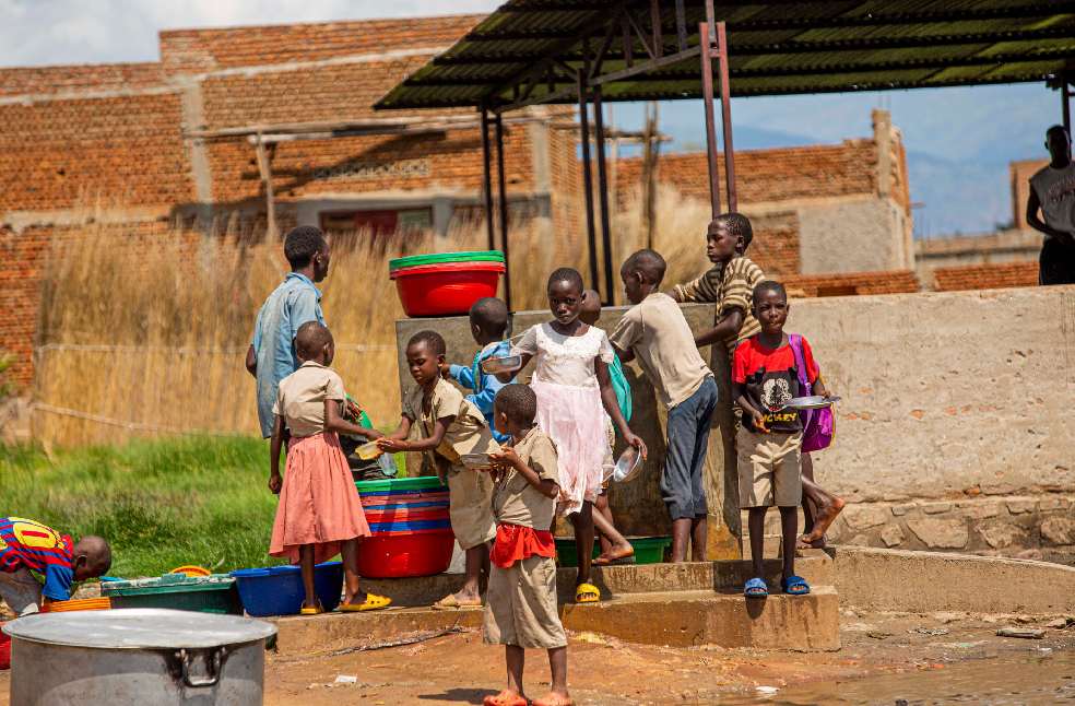Children collecting water with colorful basins outdoors