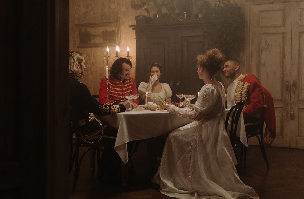 Elegant period costume dinner party with candlelight, evoking historic aristocracy