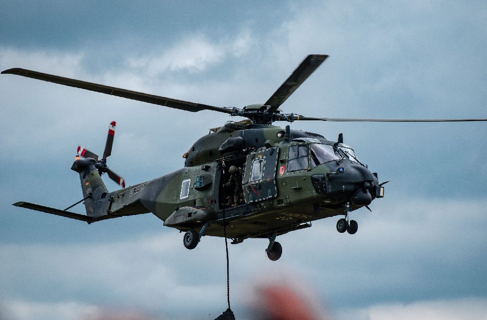 Military helicopter flying through cloudy skies during a training exercise
