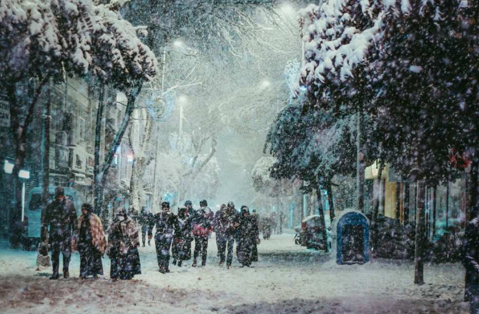 A group of people walking through a snow-covered city street