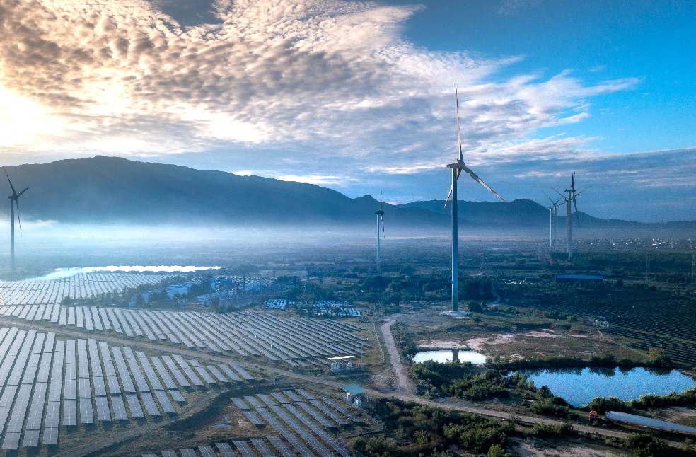 Stunning aerial view of wind turbines and solar panels in a landscape, showcasing renewable energy technologies