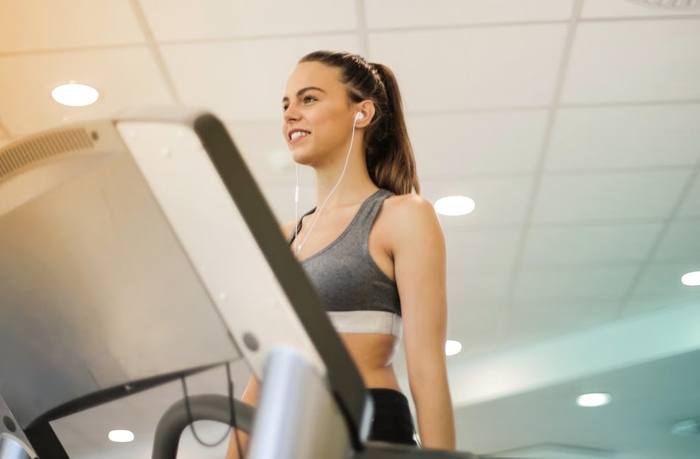 Fit woman walking on treadmill in gym