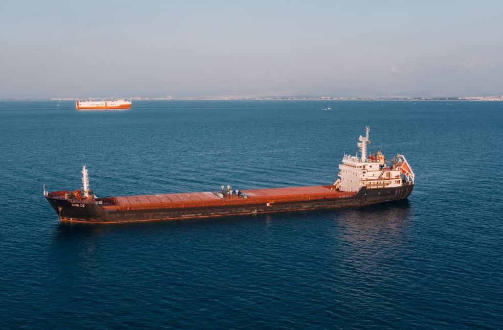 Aerial view of a cargo ship sailing in the open sea under clear skies