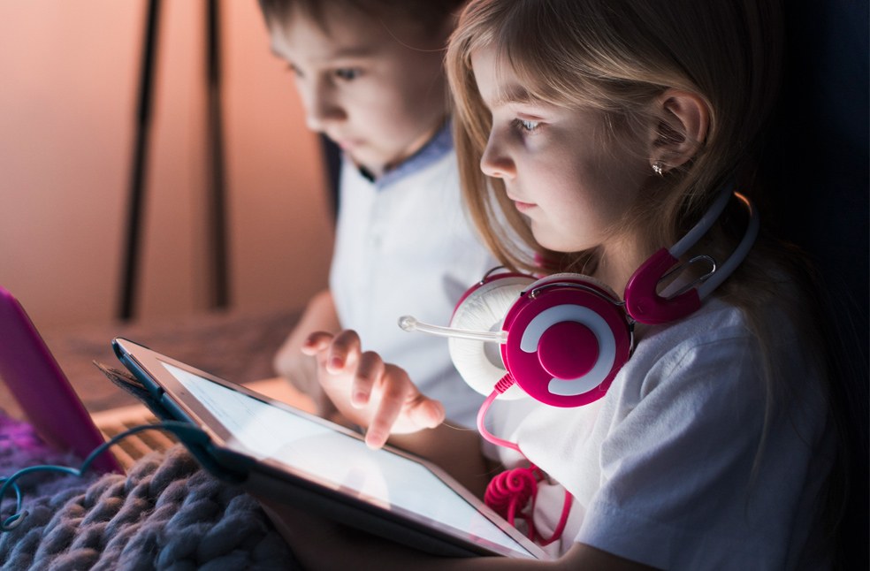 Kids looking at phones in the dark